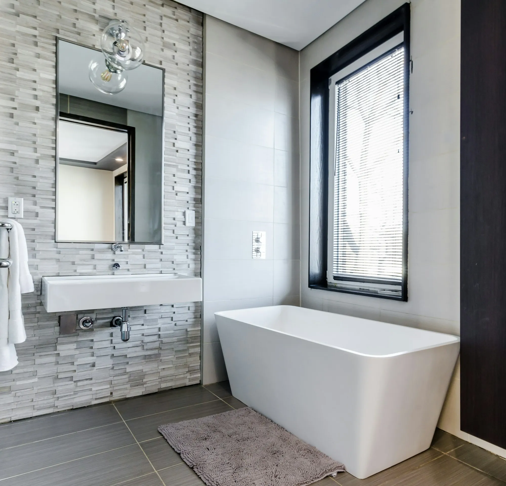 Tile setter laying wall tile in a shower during a bathroom remodel