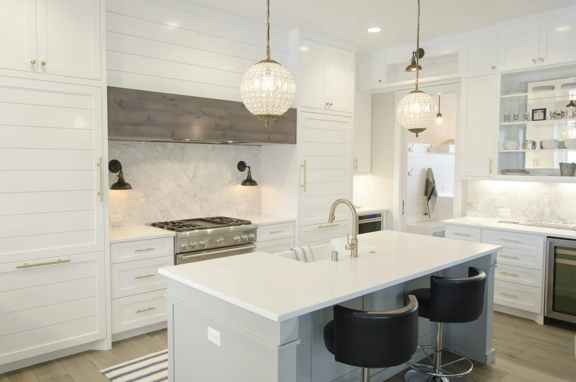Remodeled kitchen with an island, white cabinets and pendant lights